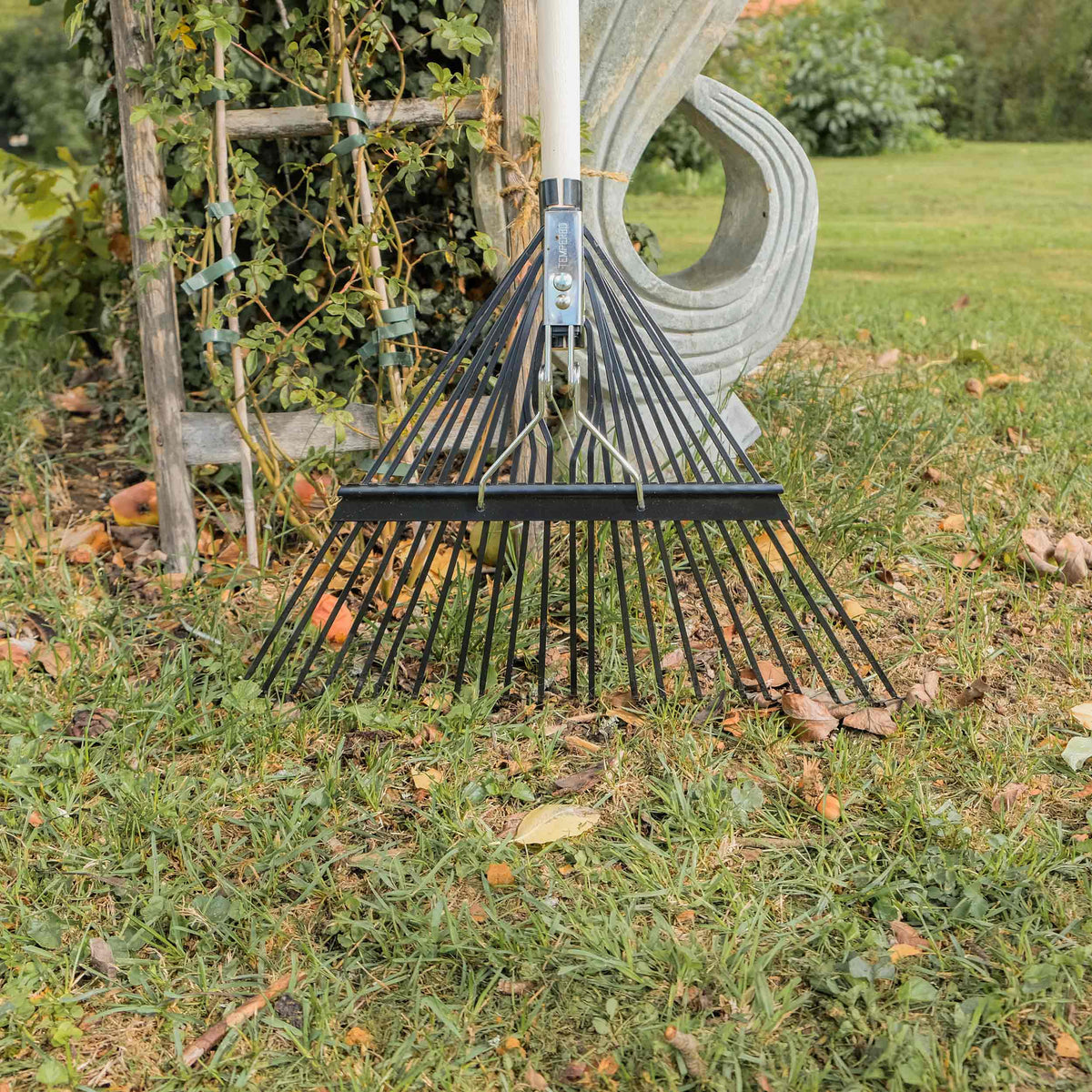 SHW Laubbesen Profi mit breitem Metallfächer auf einer Rasenfläche mit Herbstlaub, ideal zum Zusammenrechen von Blättern und zur Rasenpflege. Hero